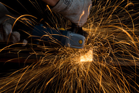Angle grinder cutting a metal square tube making a shower of sparks
