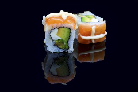 Sushi arranged on a shiny black surface looking very deliciousの写真素材