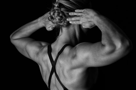 Fit woman with shaped muscles on her back in artistic conversion