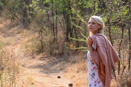 Portrait of a blonde woman outdoors walking along a trail in nature during winterの写真素材
