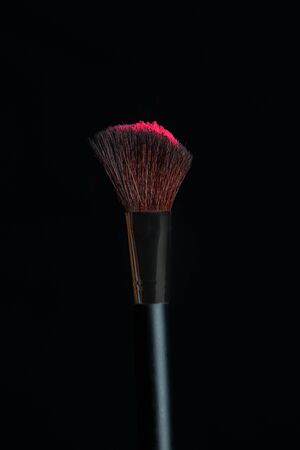 Make-up brush with pink powder isolated on a black backgroundの写真素材