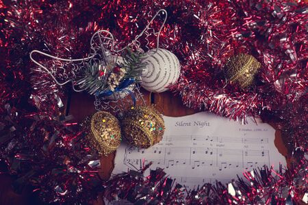 Studio photo of Christmas decorations with sheet music and glitter ballsの写真素材