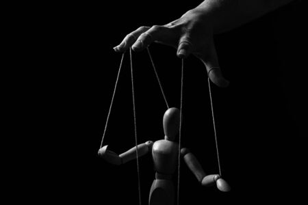 Conceptual image of a hand with strings on fingers to control a marionette in monochromeの写真素材