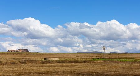 Landscape of a windmill and fields with white clouds and blue skyの写真素材