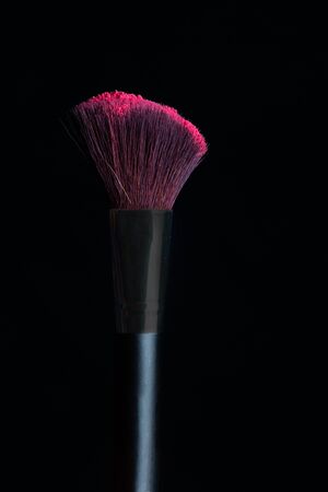 Make-up brush with pink powder isolated on a black backgroundの写真素材
