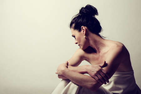 Portrait of a mature brunette woman sitting and contemplates the realities of lifeの写真素材