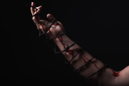 Concept photo of a hand and arm tied with barbed wire in studio artistic conversionの写真素材