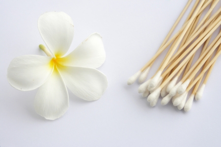 Cotton swab used for cleaning ear and Tropical flowers isolated on whiteの写真素材