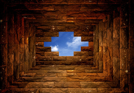 Blue sky with sunlight through the hole in the brick wall roomの写真素材