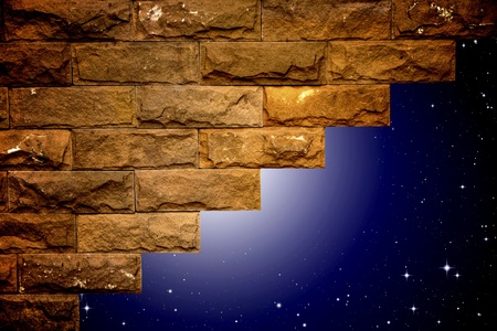 night sky with light through the hole in the brick wallの写真素材