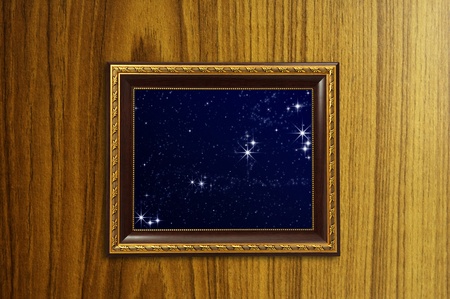 A photo of a wooden picture frame with the night sky setting inside の写真素材