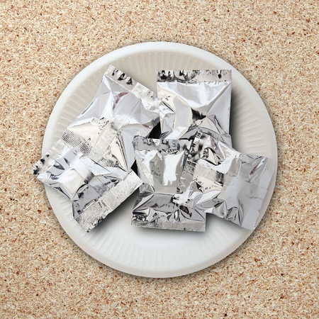 foil package on white plateの写真素材