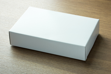 blank white paper box on dark wood backgroundの写真素材