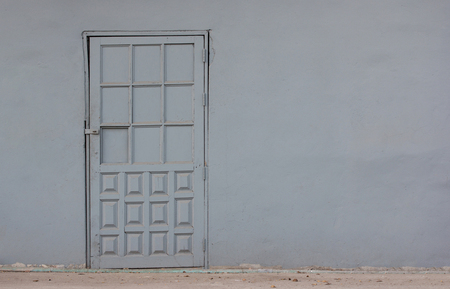 old gray door in concrete wall backgroundの写真素材