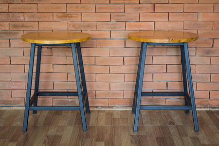 two wooden chairs on brick wall backgroundの写真素材