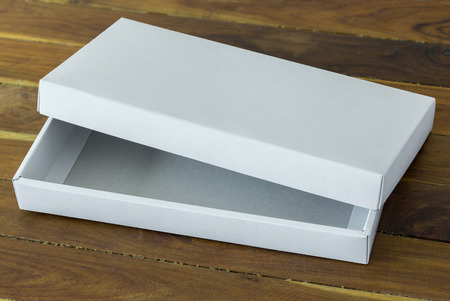 open white cardboard package box mockup on dark wooden tableの写真素材