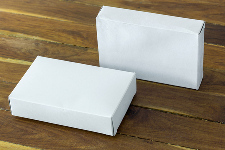 blank white cardboard package box mockup on dark wooden tableの写真素材