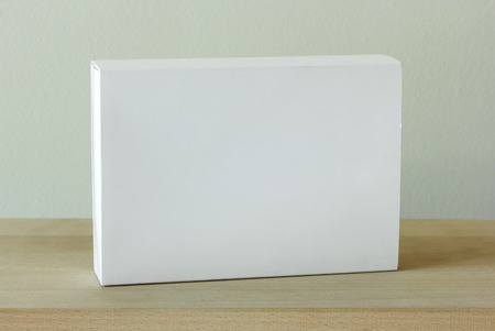 blank white cardboard package box mockup on wooden tableの写真素材