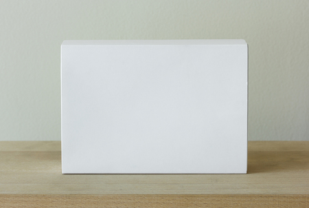 blank white cardboard package box mockup on wooden tableの写真素材