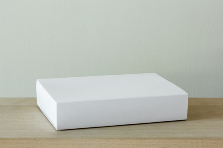 blank white cardboard package box mockup on wooden tableの写真素材