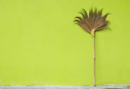 Broom on green wall backgroundの写真素材