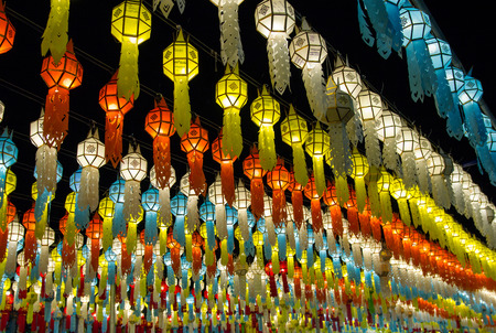colorful hanging lanterns lighting on night sky in loy krathong festival at northern of thailandの写真素材