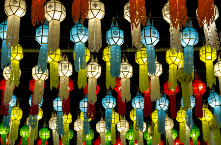 colorful hanging lanterns lighting on night sky in loy krathong festival at northern of thailandの写真素材