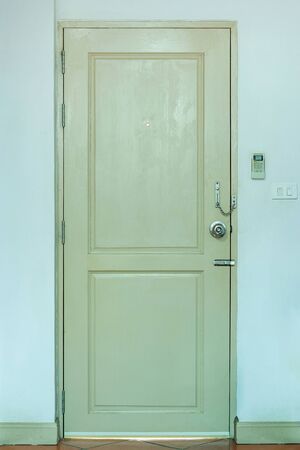 Wooden Door with Light Switch and Air Conditioner Remote in the Roomの写真素材