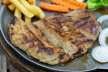 Close up of Grilled Pork Steaks and French Fries with Vegetableの写真素材