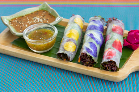 Fresh Vegetable Salads Roll with Colorful Flower and Sauce on Wooden Board