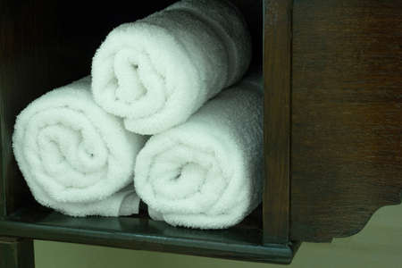 Stack of White Towel in Wooden Shelf on the Tableの写真素材