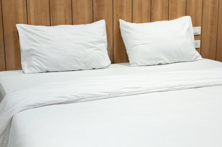 Modern bedroom interior with white pillow and blanket on bedの写真素材