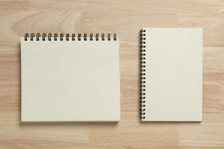 two blank spiral notebook on wooden table for mockup blank templateの写真素材