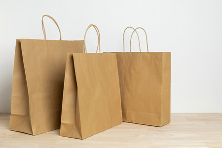 three brown paper bag on wooden table for mockup blank templateの写真素材