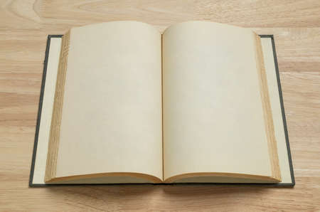 open old book on wooden table for mockup blank templateの写真素材