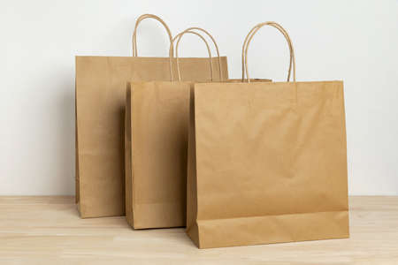three brown paper bag on wooden table for mockup blank templateの写真素材
