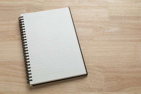blank spiral notebook on wooden table for mockup blank templateの写真素材