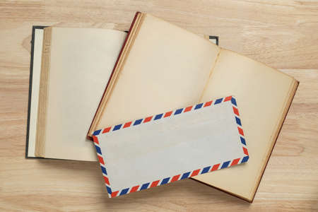 envelope and old book on wooden table for mockup blank templateの写真素材