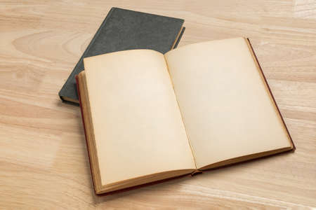 stack of open old book on wooden table for mockup blank templateの写真素材
