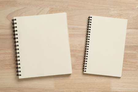two blank spiral notebook on wooden table for mockup blank templateの写真素材