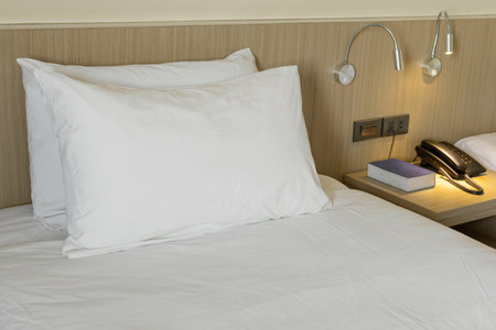 Modern bedroom interior with white pillow and bedside tablesの写真素材
