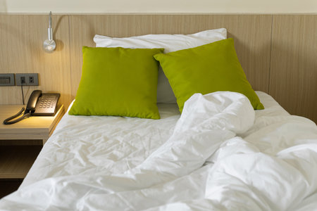 Messy bed sheets and pillow in the morning at bedroomの写真素材
