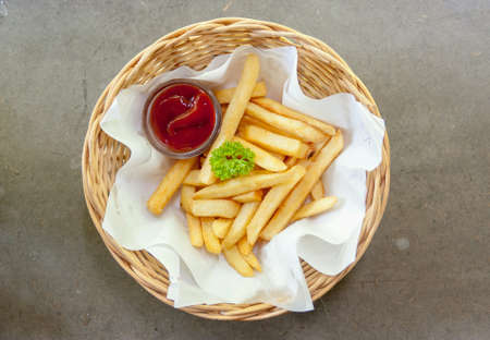 French fries in basket on grey colored tableの素材