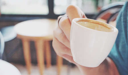 Woman hand holding white coffee cupの写真素材