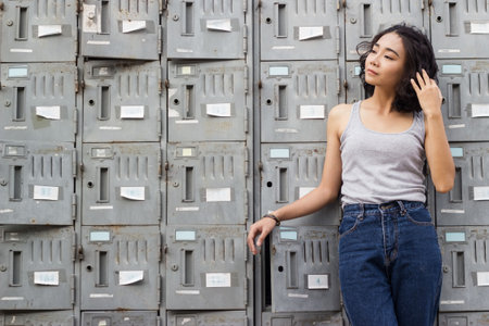 portrait of young woman standing against a old metal lockers background