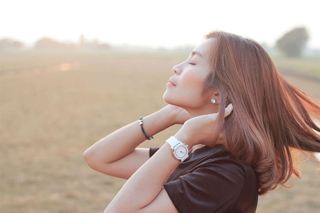woman relaxing and touch long hair on meadow natureの写真素材