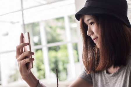 young hipster woman making selfie by her smart phone, urban life concept.
