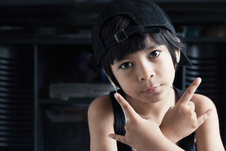 adorable asian little boy listening rock music from earphoneの写真素材