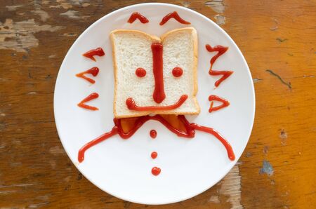 a bread food breakfast with smiley face writing with ketchup for kids meal.の写真素材