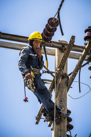Electrician smoking while resting on the electricity poleのeditorial素材